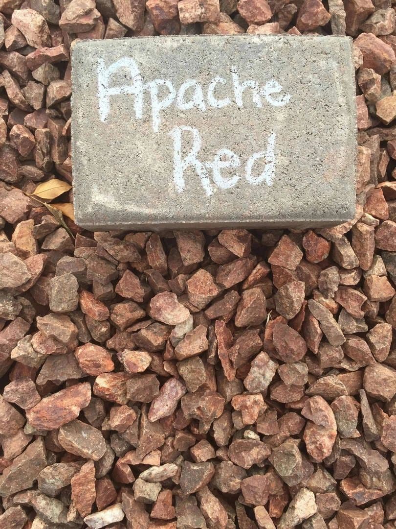 Apache Red stone sample on a bed of small gravel rocks for landscaping use.