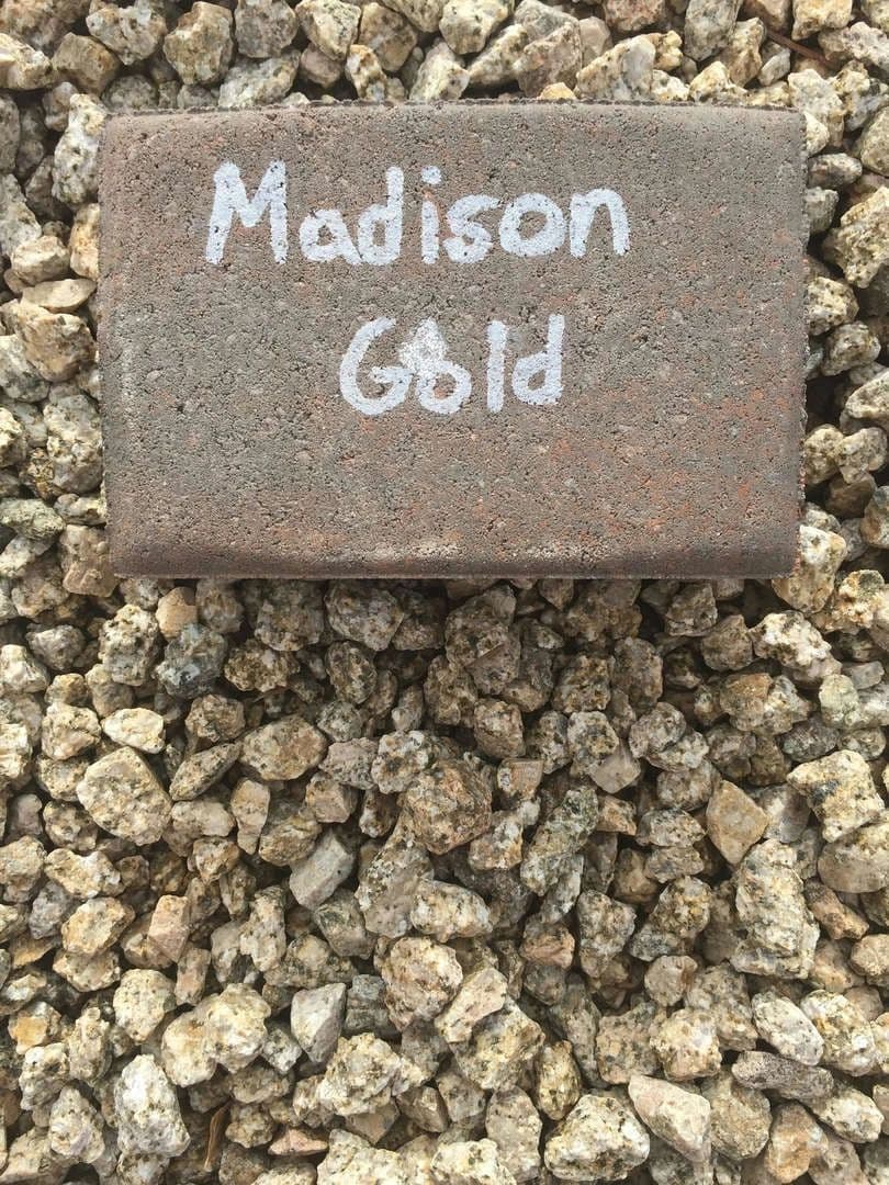 Madison Gold stone brick resting on a bed of gravel. Suitable for landscaping projects.